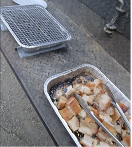 Pulled pork in a foil tray on a grill